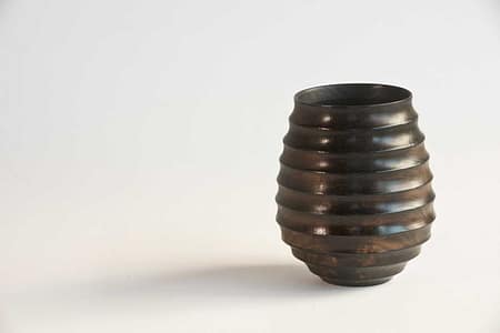 Hollowed wooden vessel with natural grain showing beneath fire-blackened finish.